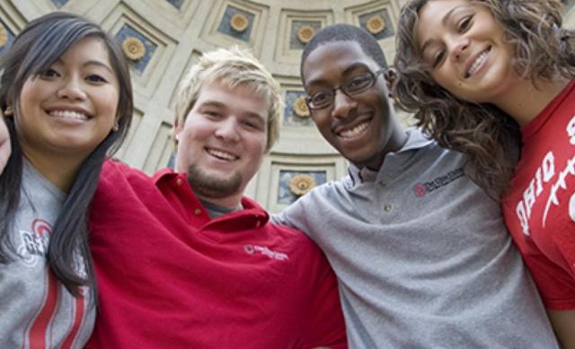 Students posing for a picture with arms linked under the Ohio Stadium rotunda.