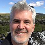 A man with gray hair smiles