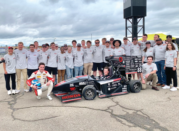 The 2023 Formula Buckeyes team, including President Colin Mullan (kneeling to left of car) and aerodynamics director Kathryn Nestlerode (back row, 11th from left).