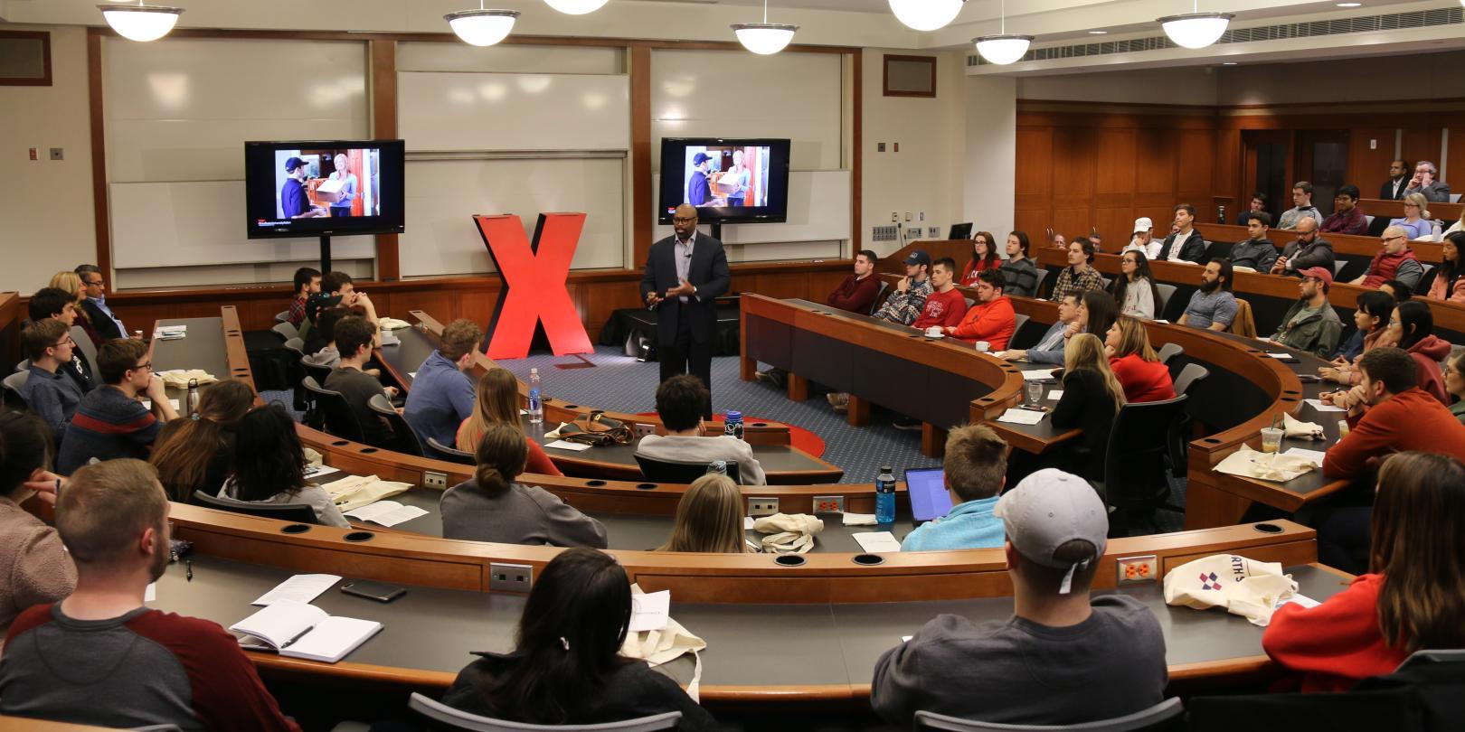 College lecture hall with a person giving a presentation