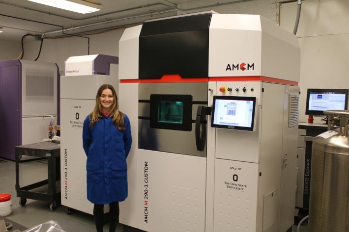 Student beside a 3-D printer