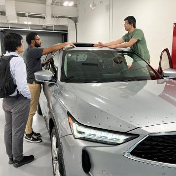 Students beside a car