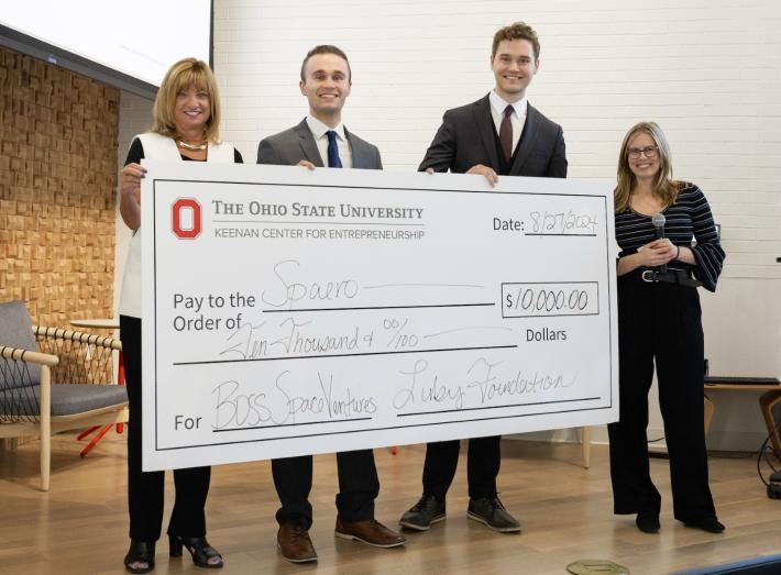 Educators and students presenting an oversized check