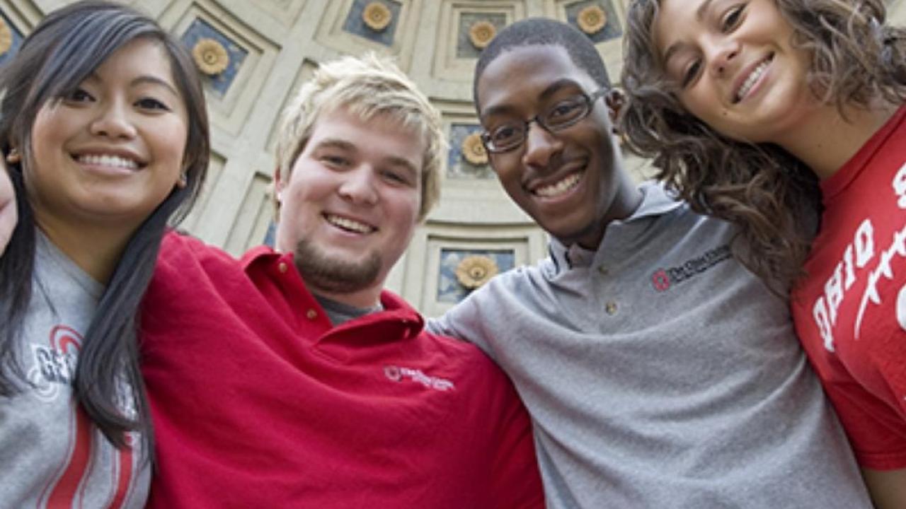 Students posing for a picture with arms linked under the Ohio Stadium rotunda.