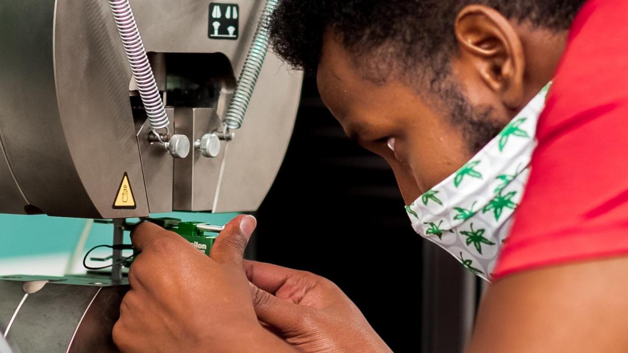 CDME Student performing an experiment using a machine.